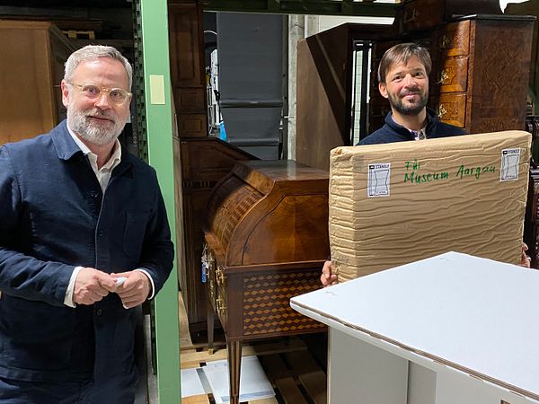 Jonas Studer übergibt Rudolf Velhagen (Chefkurator Sammlung & Ausstellung) das Stehpult "Standly" für die Sammlung Museum Aargau.