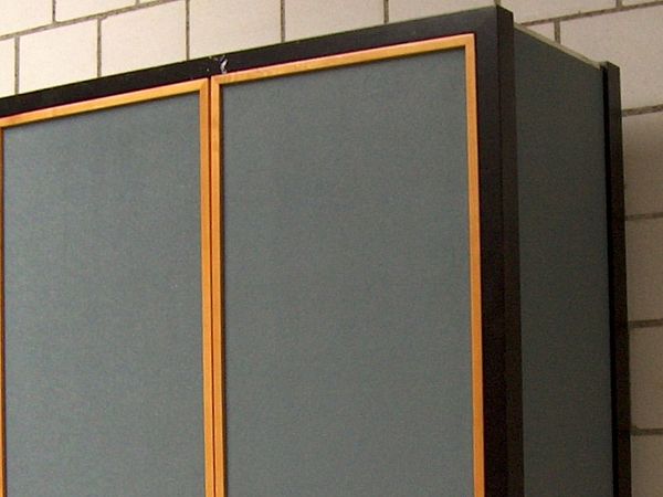 Ein Pavatexschrank der Möbelfabrik Thut Möriken steht vor einer Mauer.
