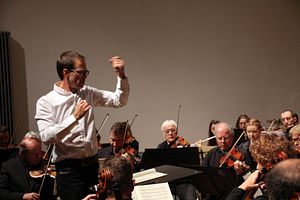 Dirigent steht vor Orchester