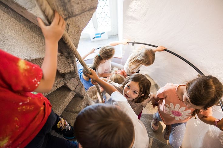 Mehrere Kinder gehen eine Wendeltreppe im Schloss Lenzburg hoch.