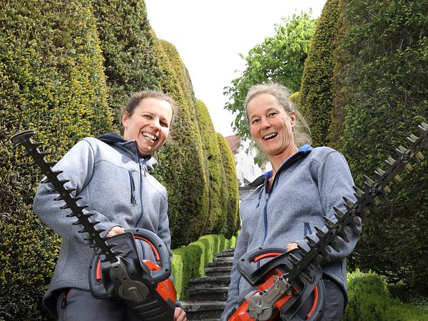 Zwei Gärtnerinnen stehen mit Heckenscheren im Garten von Schloss Wildegg