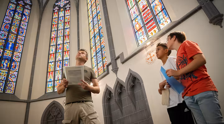 Besucher und Besucherinnen betrachten die berühmten Glasfenstern auf Kloster Königsfelden