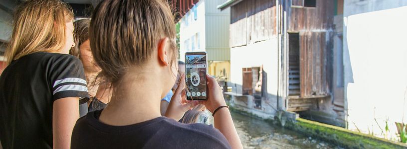 Zwei Schülerinnen auf dem Industriekultour Aabach mit einem Handy