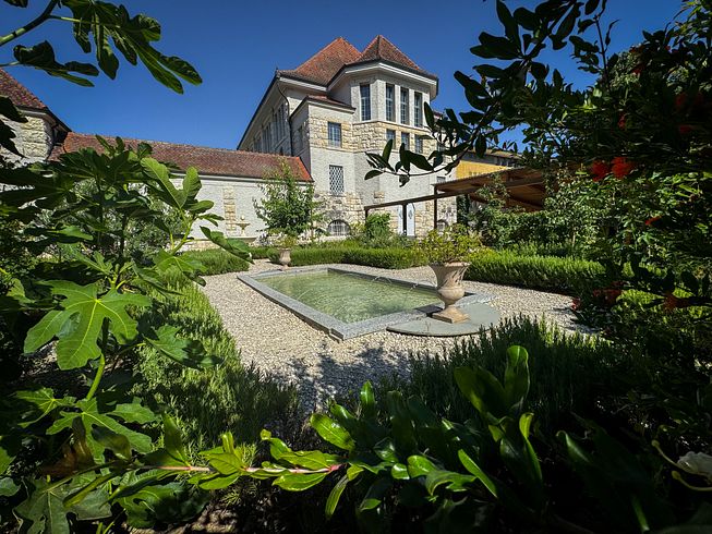 Römischer Garten Vindonissa Museum: Übersicht des Gartens mit geometrisch angelegten Wegen und Gartenbeeten. Im Hintergrund das Museumsgebäude vom Vindonissa Museum.