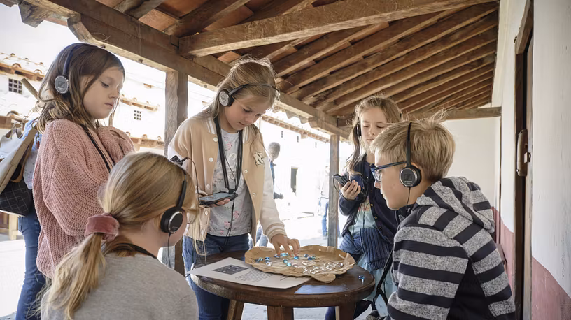 Mehrere Kinder spielen ein römisches Würfelspiel