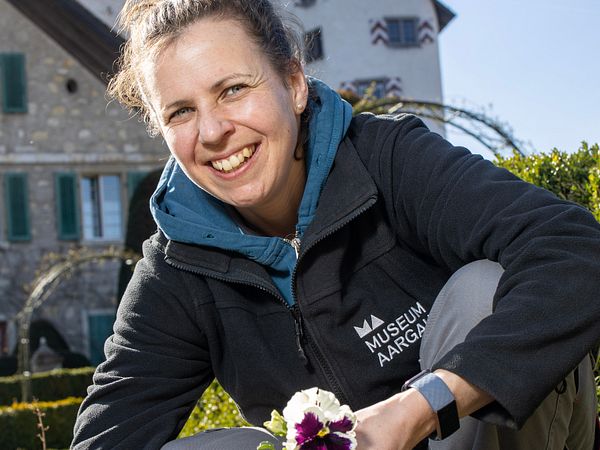 Gärtnerin Melissa Gögele im Rosengarten von Schloss Wildegg (im Hintergrund das Rebhaus und Schloss Wildegg)