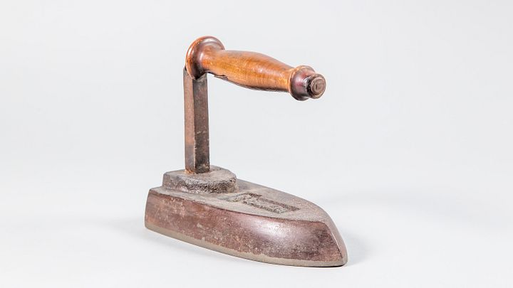 Historisches altes Bügeleisen aus der Sammlung Museum Aargau auf weissem Grund.