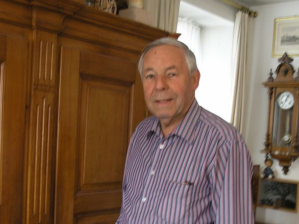 Sepp Schmid, der in einer Wohnung steht, im Podcast von Museum Aargau.