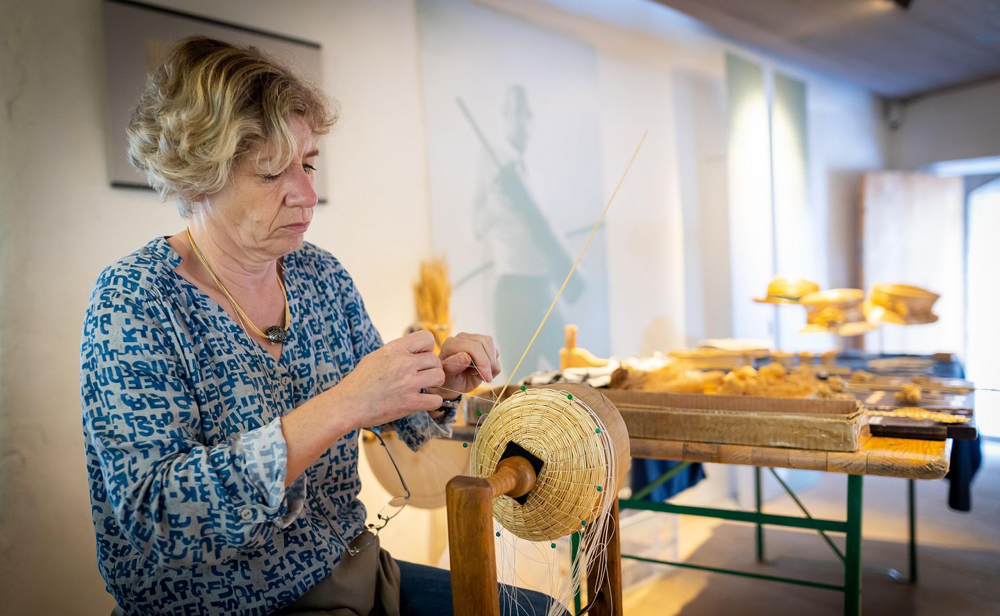 Eine Frau beim Strohflechten