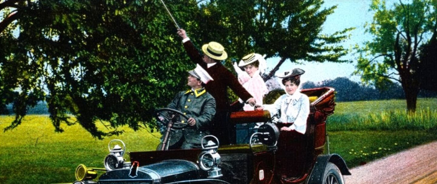 Historische Aufnahme: Altes Auto mit einer Reisegesellschaft.