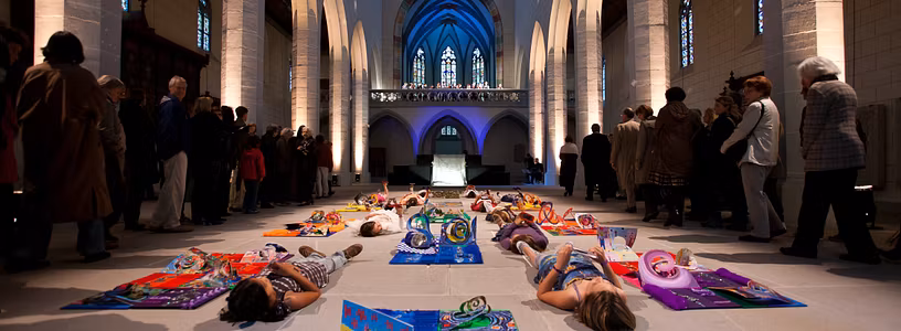 Produktion "Tor zum Paradies" Kloster Königsfelden: Mehrere Kinder liegen in Farben getaucht auf dem Boden der Klosterkirche.