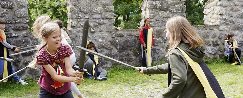 Zwei Mädchen beim Duell mit Schwertern auf Schloss Hallwyl (Workshop für Schulen),