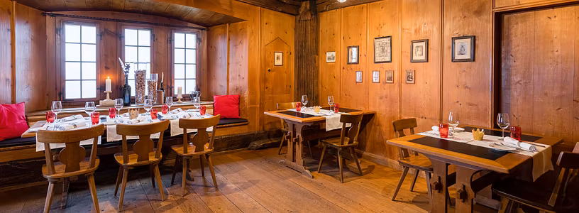 Gotische Stube Schloss Habsburg: Rustikaler Raum mit viel Holz und schön gedeckten Tischen.