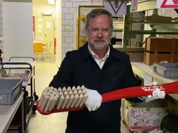 Chefkurator Rudolf Velhagen hält eine grosse "Walther Bürste" aus der Sammlung Museum Aargau.