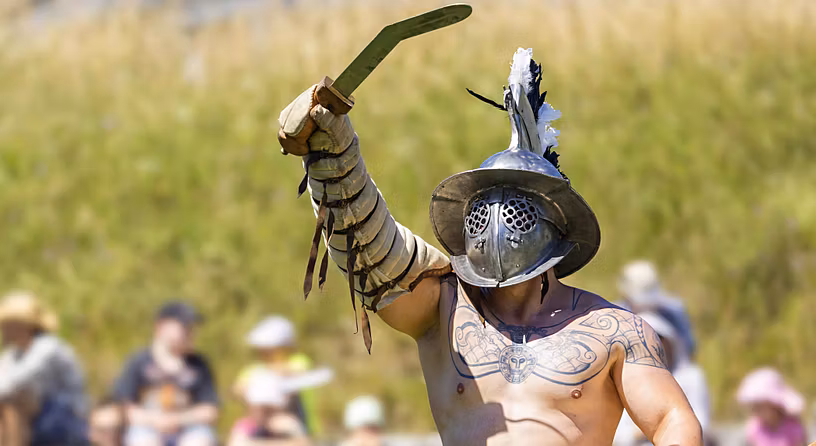 Gladiator hebt sein Schwert im Amphitheater Windisch