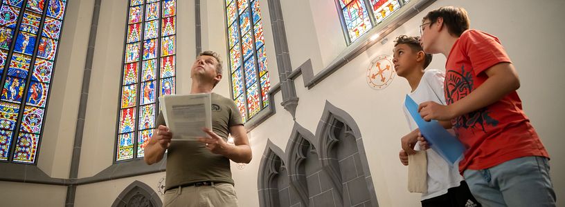 Besucher und Besucherinnen betrachten die berühmten Glasfenstern auf Kloster Königsfelden