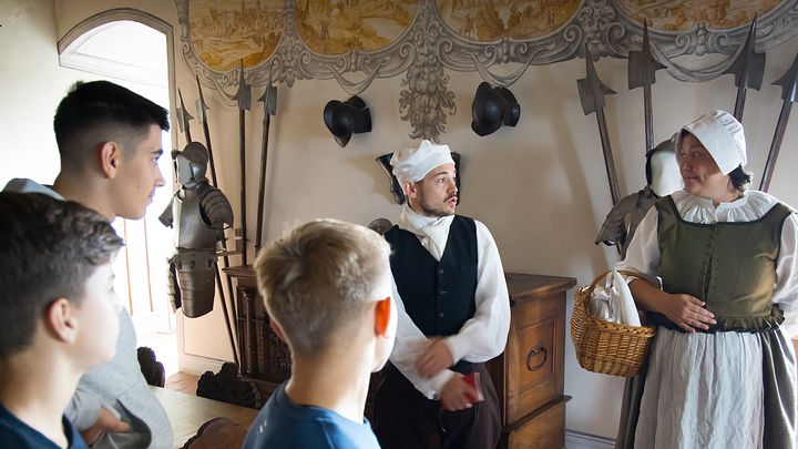 Ein Knecht und eine Magd mit Schulklasse im Wohnmuseum von Schloss Wildegg