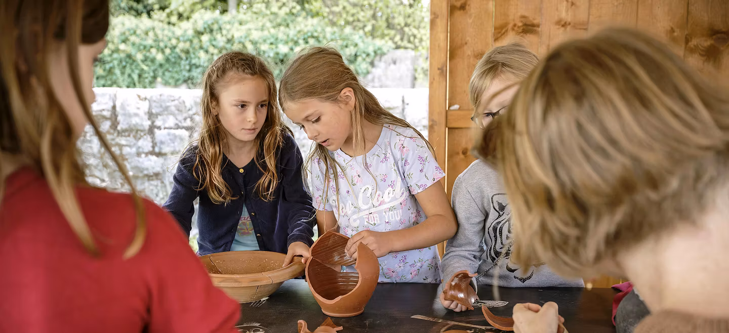 Kinder setzen im römischen Garten vom Vindonissa Museum Scherben eines Kruges zusammen.