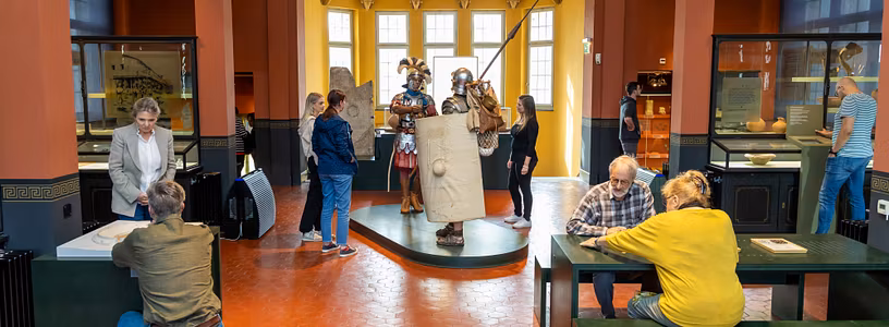 Blick in einen Ausstellungsraum des Vindonissa Museum. Der Raum ist bevölkert mit vielen Besuchenden, in der Mitte zwei lebensgrosse Legionäre.