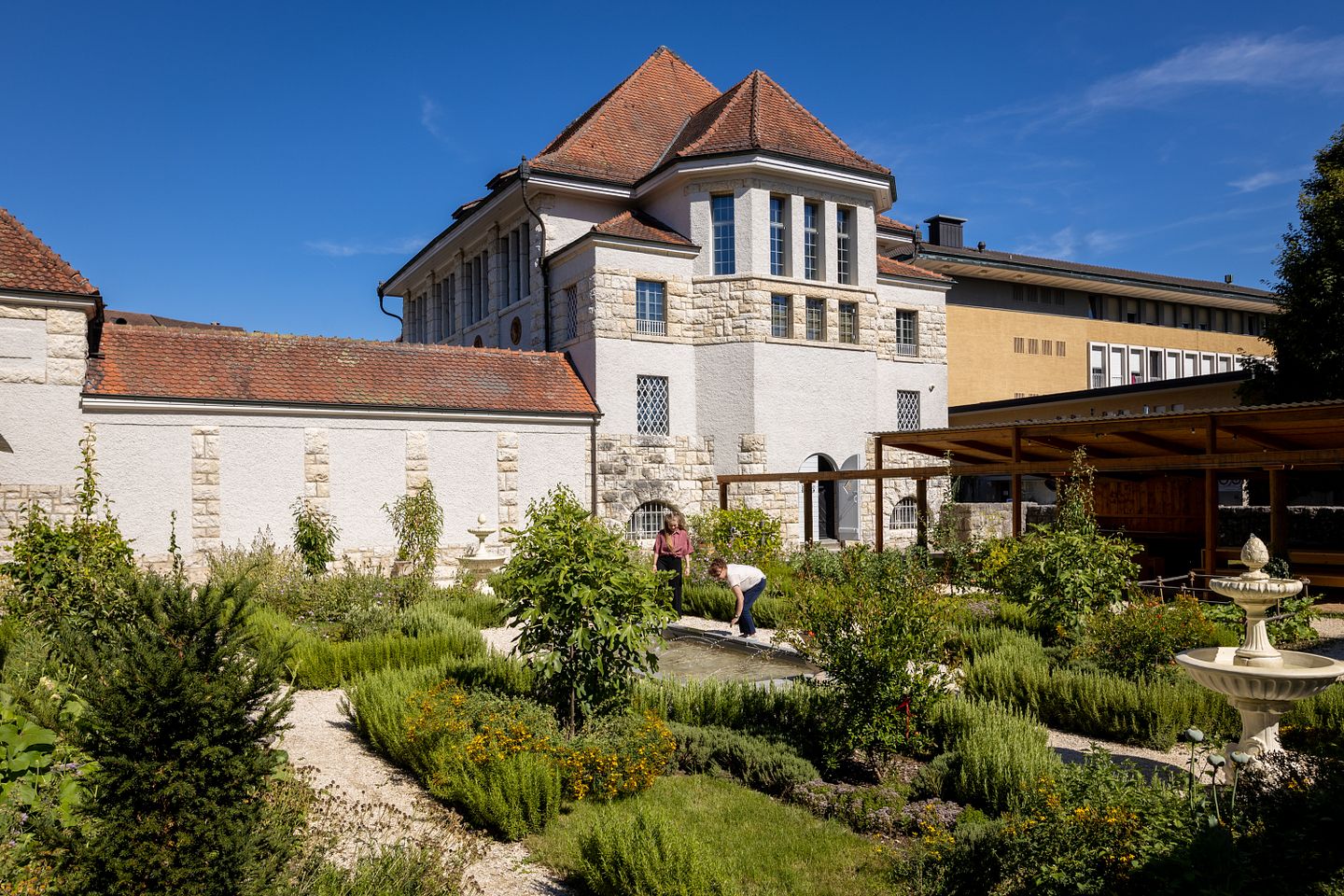 Römischer Garten Vindonissa Museum: Übersicht des Gartens mit geometrisch angelegten Wegen und Gartenbeeten. Im Hintergrund das Museumsgebäude vom Vindonissa Museum.