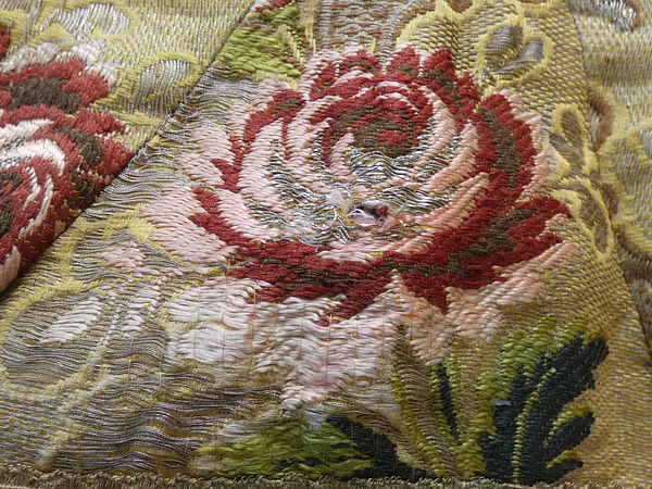 Bildausschnitt von einem Marienkleid mit Blumenaufdruck. 