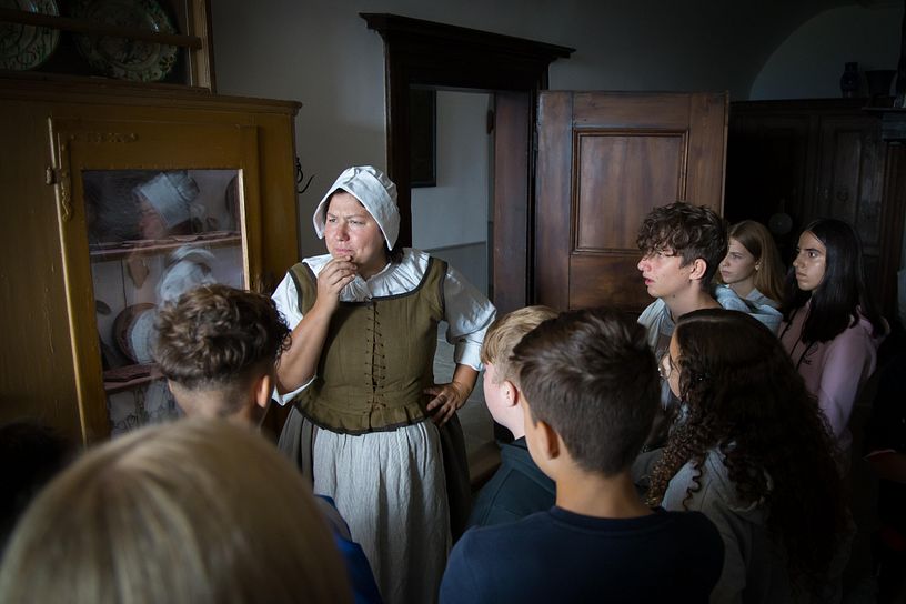 Magd erzählt auf Schloss Wildegg einer Gruppe von Kindern aus ihrem Leben