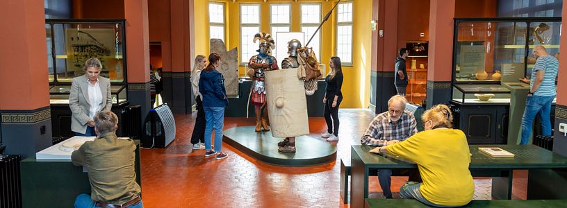 Blick in einen Ausstellungsraum des Vindonissa Museum. Der Raum ist bevölkert mit vielen Besuchenden, in der Mitte zwei lebensgrosse Legionäre.