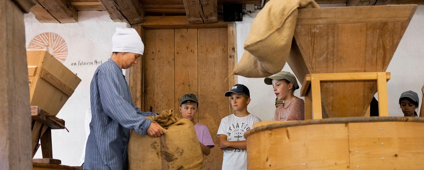 Führung einer Schulklasse durch die historische Mühle auf dem Gelände von Schloss Hallwyl.