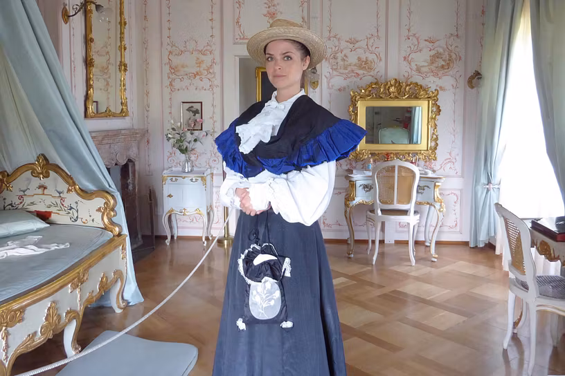 Eine als Lady Mildred gekleidete Frau führt durch die Räume von Schloss Lenzburg.