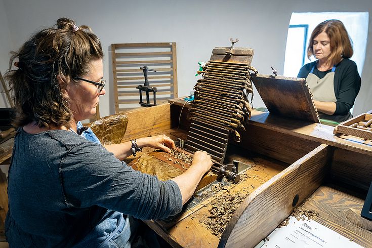 Zwei Frauen rollen auf Schloss Hallwyl Zigarren.