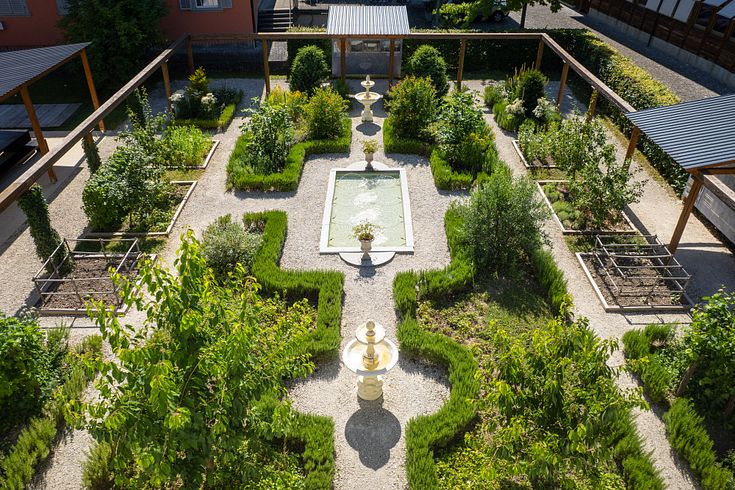 Römischer Garten Vindonissa Museum: Übersicht des Gartens mit geometrisch angelegten Wegen und Gartenbeeten. Im Hintergrund das Museumsgebäude vom Vindonissa Museum.