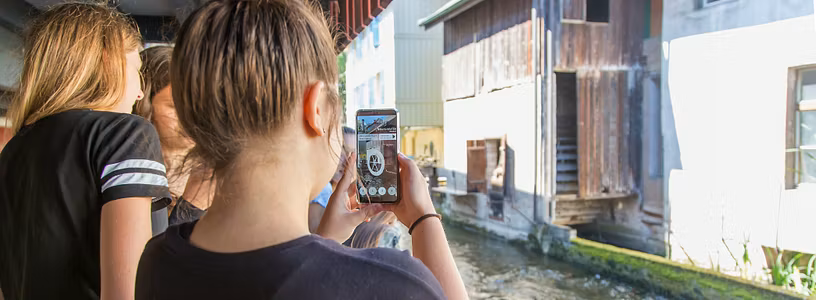 Zwei Schülerinnen auf dem Industriekultour Aabach mit einem Handy