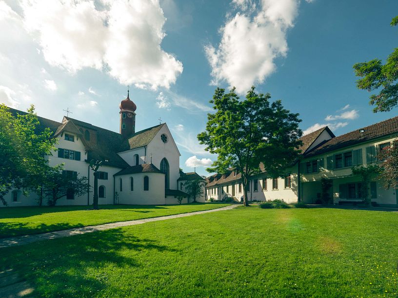Aussenaufnahme Kloster Wettingen mit blauen Himmel und einer grünen Wiese im Vordergrund.
