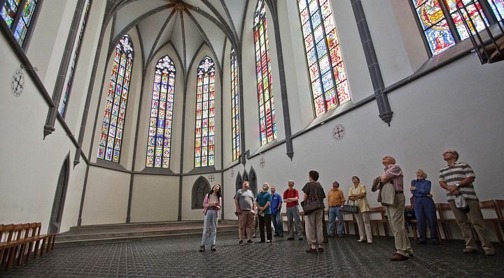 Besucher und Besucherinnen bei der Führung im traumhaften Kloster Königsfelden mit Glasfenstern