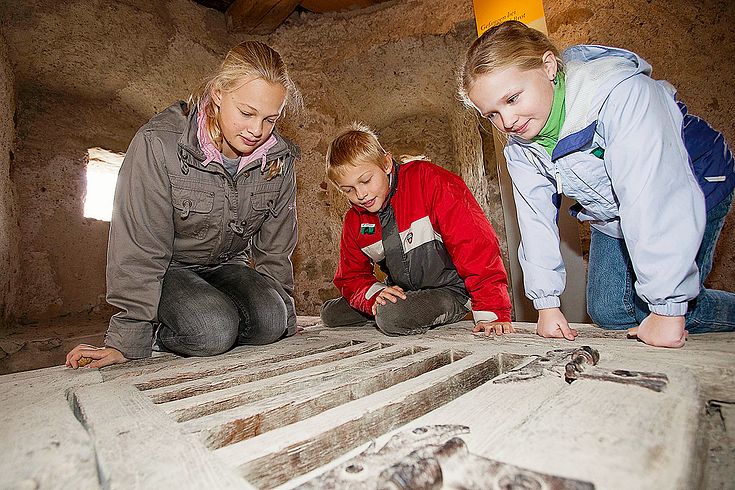 Kinder betrachten durch die Dohle das Gefängnis im Schloss Hallwyl