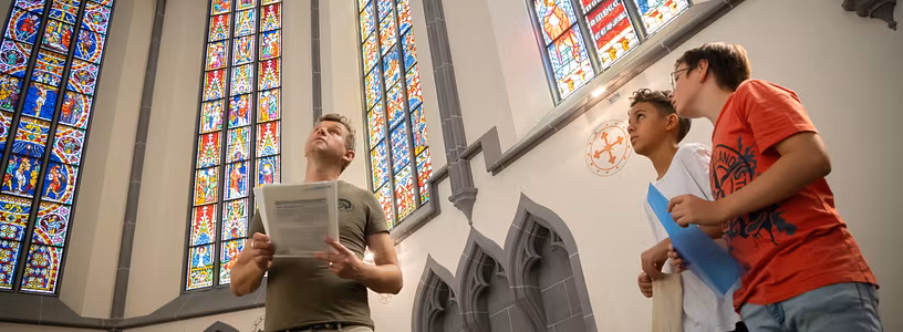 Besucher und Besucherinnen betrachten die berühmten Glasfenstern auf Kloster Königsfelden