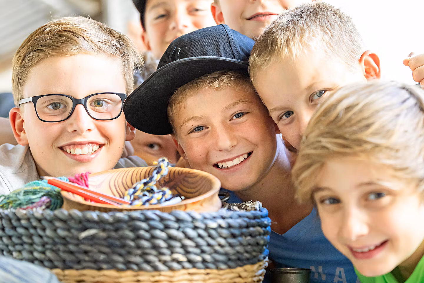 Mehrere Kinder strecken ihre Köpfe zusammen und blicken direkt in die Kamera
