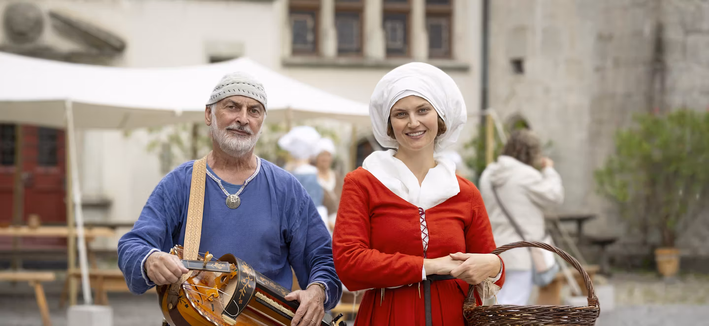Eine mittelalterlich gekleidete Frau und ein mittelalterlicher Musiker.