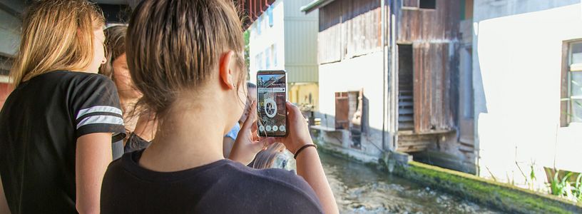 Zwei Schülerinnen auf dem Industriekultour Aabach mit einem Handy