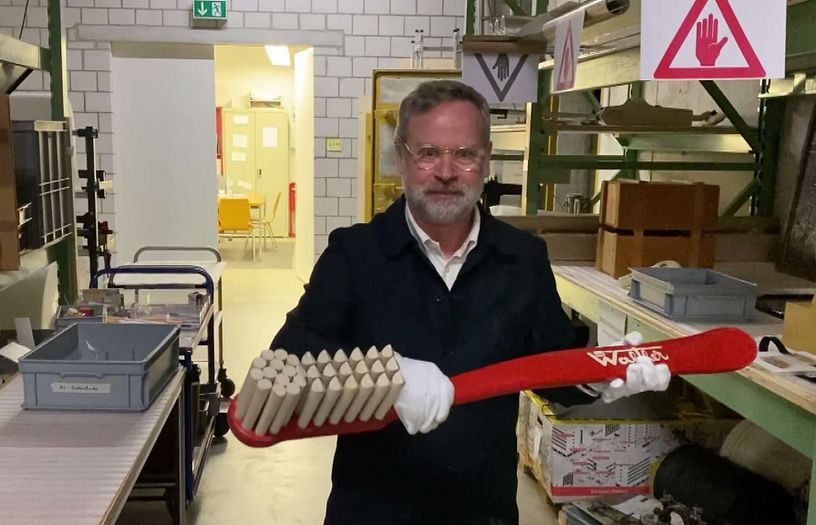 Chefkurator Rudolf Velhagen hält eine grosse "Walther Bürste" aus der Sammlung Museum Aargau.
