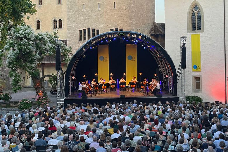 Eine Konzertbühne mit viel Publikum im Hof von Schloss Lenzburg