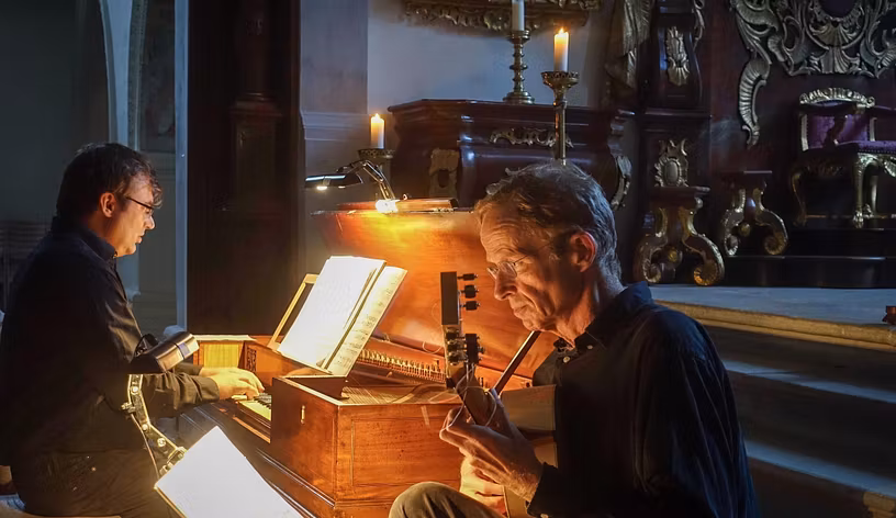 Zwei Männer musizieren an zwei Instrumenten.