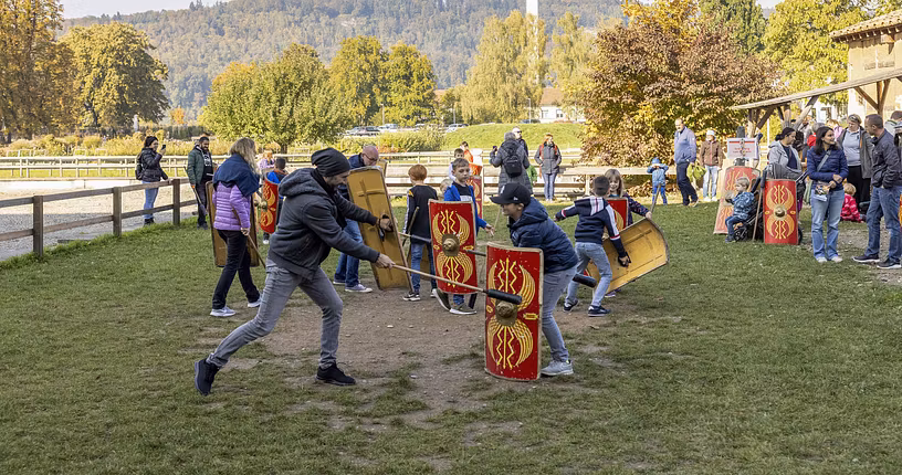 Eine Gruppe Eltern und Kinder kämpfen im Legionärspfad Vindonissa gegeneinander.