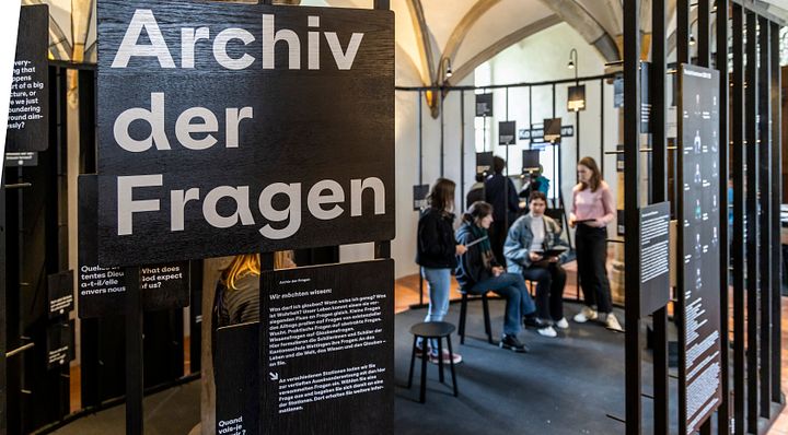 Mehrere Personen stehen und sitzen im Archiv der Fragen im Parlatorium auf der Klosterhalbinsel wettingen