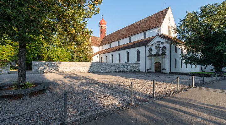 Blick auf die Klosterkirche Wettingen von der Strasse, im Vordergrund ein steinerner Vorplatz.