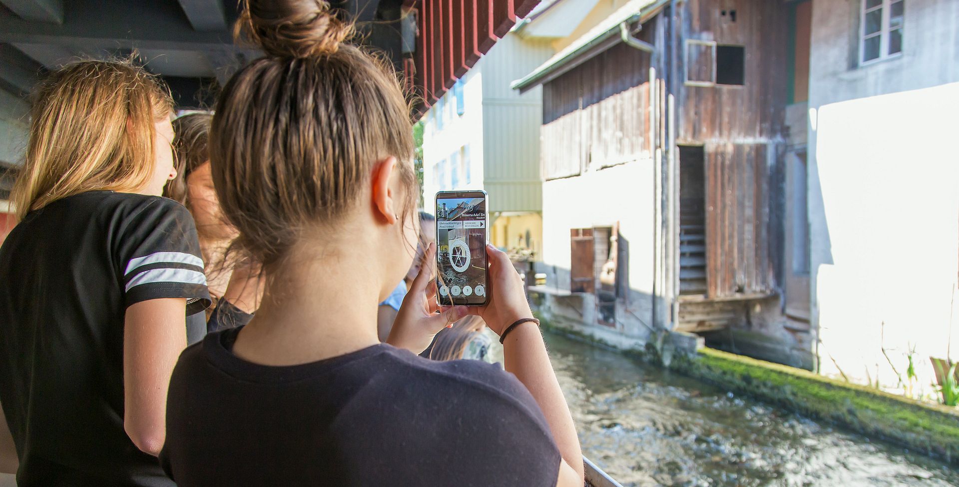 Zwei Schülerinnen auf dem Industriekultour Aabach mit einem Handy