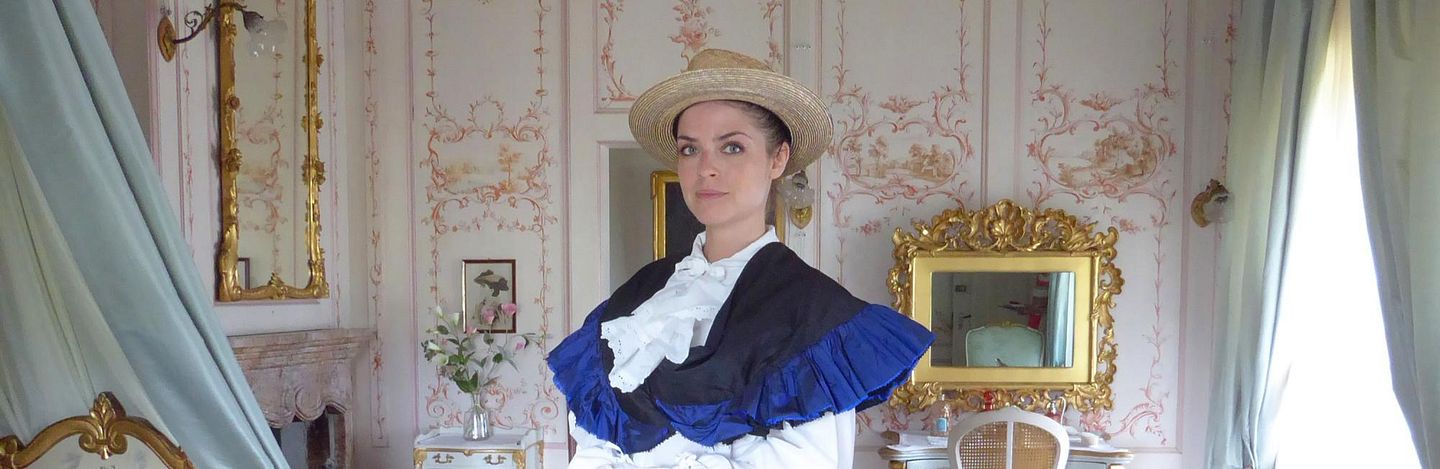 Eine Schauspielerin in historischer Kleidung (Lady Mildred) in einem Ausstellungsraum von Schloss Lenzburg