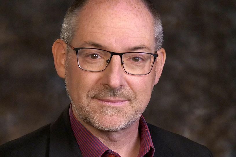 Porträtbild Dr. Christian Rutishauser vor schwarzem Hintergrund