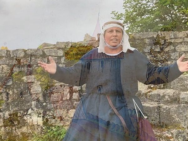 Eine als Anna von Habsburg gekleidete Person steht vor der Ruine auf Schloss Habsburg.