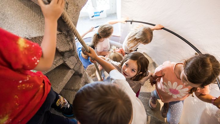 Mehrere Kinder steigen im Schloss Lenzburg eine Wendeltreppe hoch.